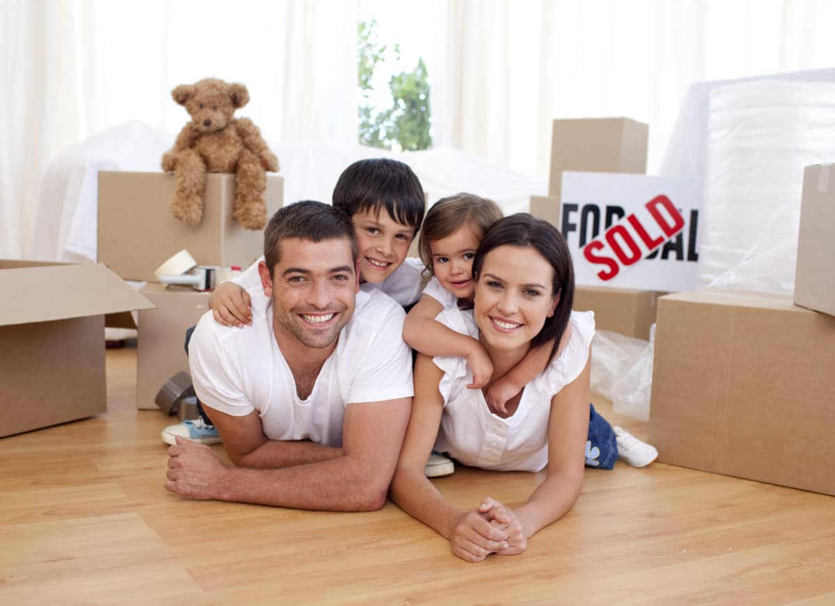 Happy homeowners lying on floor after buying new house